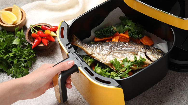 a whole fish and vegetables cooked in a simple air fryer