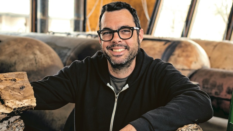 Aaron Franklin smiling in wood pile