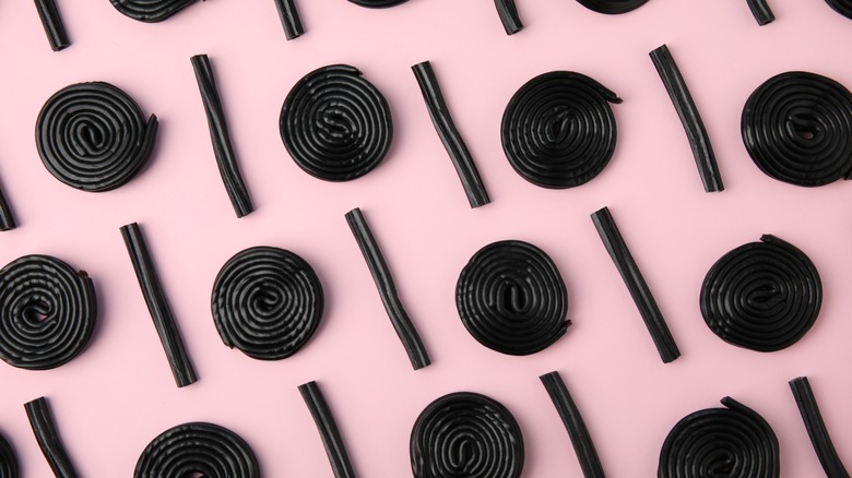  black licorice candy pink background