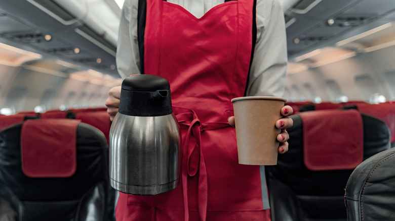 flight attendant serving coffee on a plane