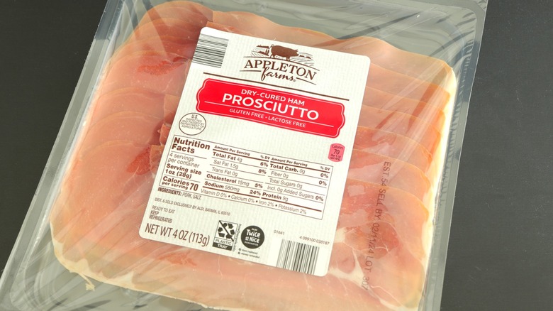 Plastic pack of Appleton Farms prosciutto on black surface