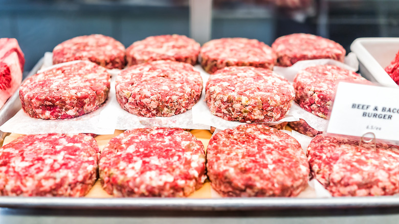 raw ground beef burger patties on display