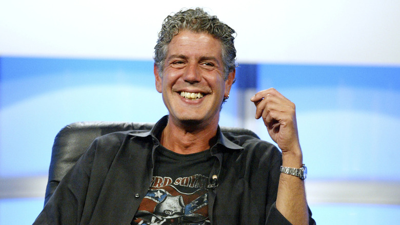 Anthony Bourdain smiling with a t-shirt and button-down