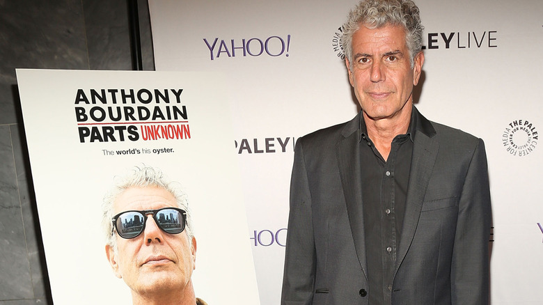 Anthony Bourdain at a Parts Unknown live event wearing a black shirt and dark jacket