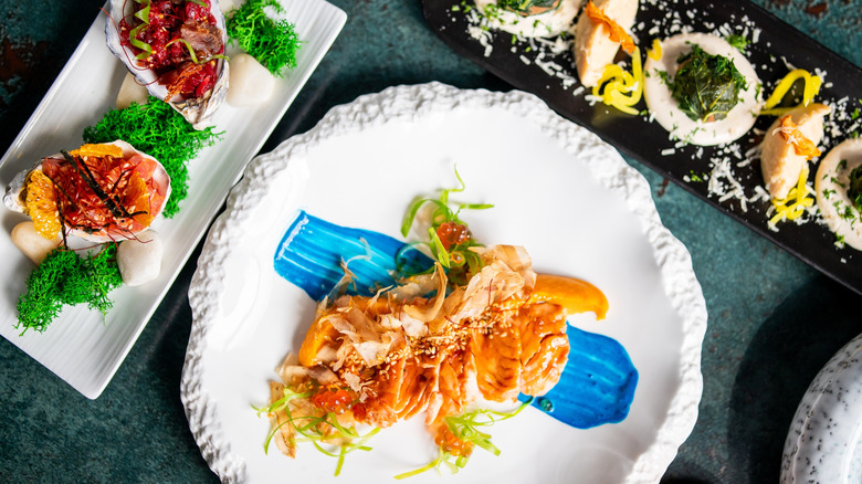 Gourmet seafood dishes presented on white plates at a luxury restaurant