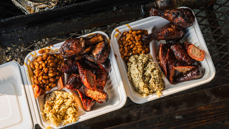 Plates of barbecue food in takeout containers