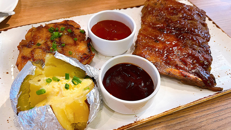 Sizzler meal with ribs, salmon, and a baked potato