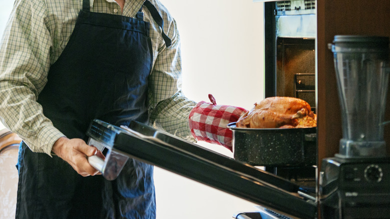 older boomer man roasting chicken