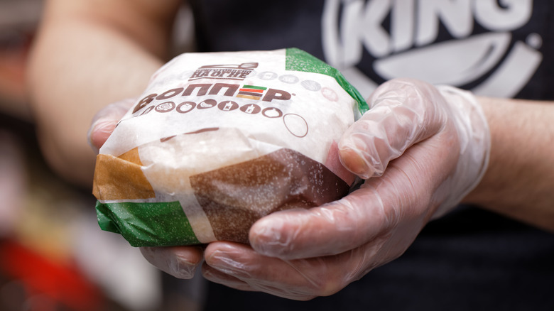 Hands holding Russian Burger King burger