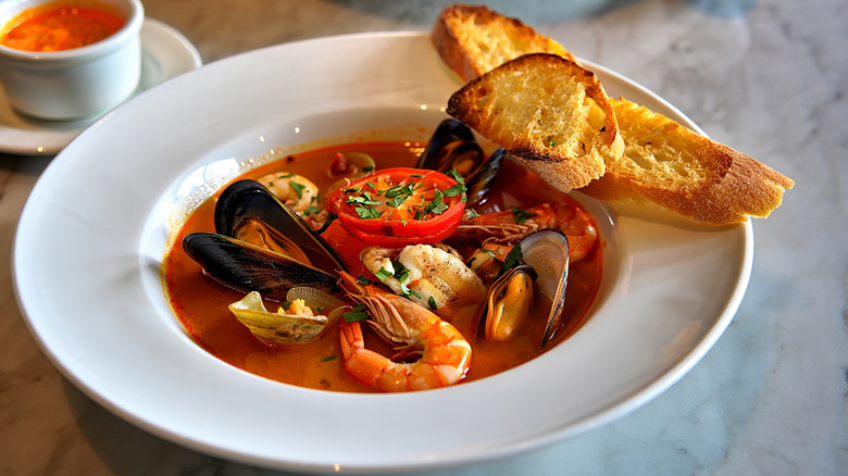 a bowl of bouillabaisse and toasted bread