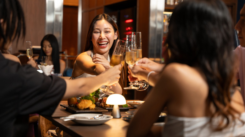 Friends cheersing flute glasses at a restaurant