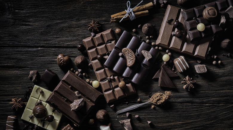 Chocolate bars and ingredients on wooden table
