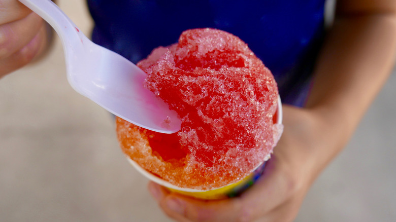 Person eating cherry snow cone