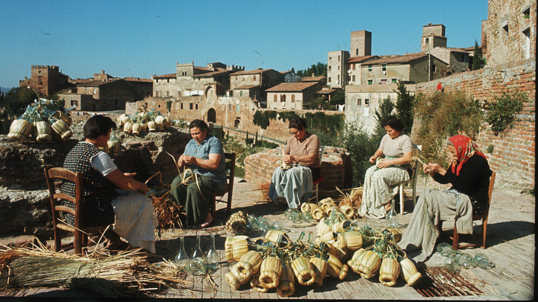 Vintage image of Italian women, fiascaie, weaving straw around chianti bottles.