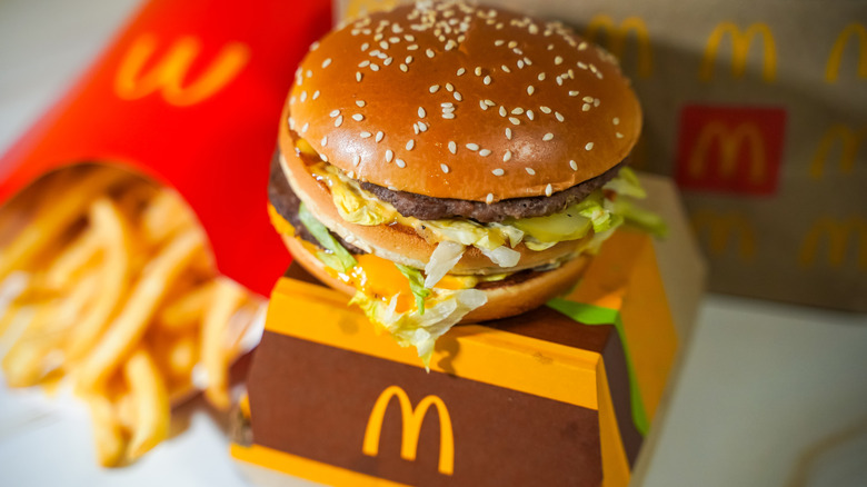 A McDonald's meal, with a double burger with a sesame seed bun and fries nearby.