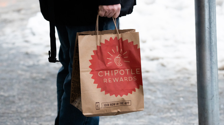 Person holding Chipotle bag in snow