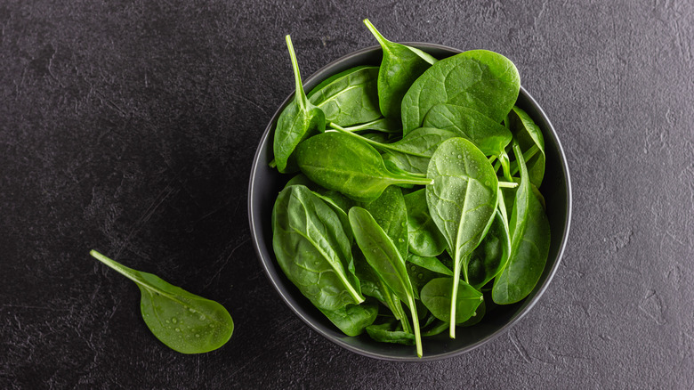 Overhead view of a bowl with fresh spinach leaves