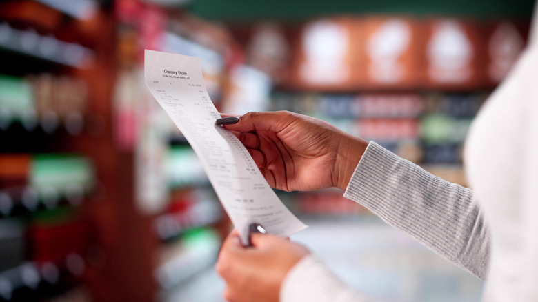 woman holding a grocery receipt