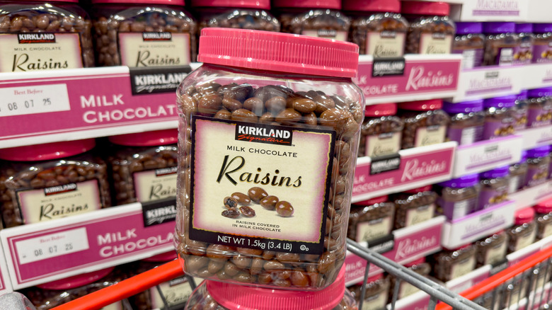 A box of Kirkland Milk Chocolate Raisins in front of filled shelves