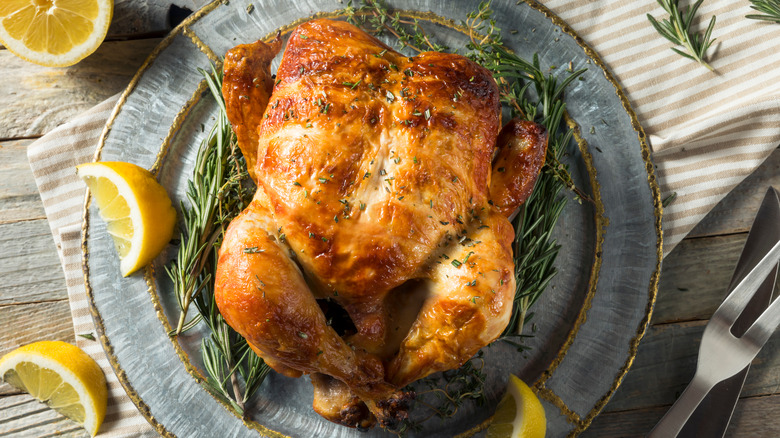 rotisserie chicken on plate with lemons