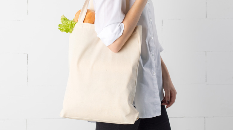 A woman carrying a white cotton tote