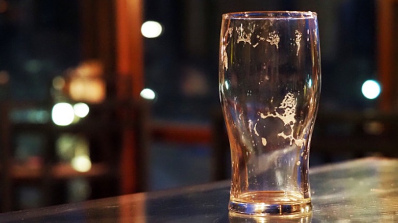 an empty pint of beer on a bar