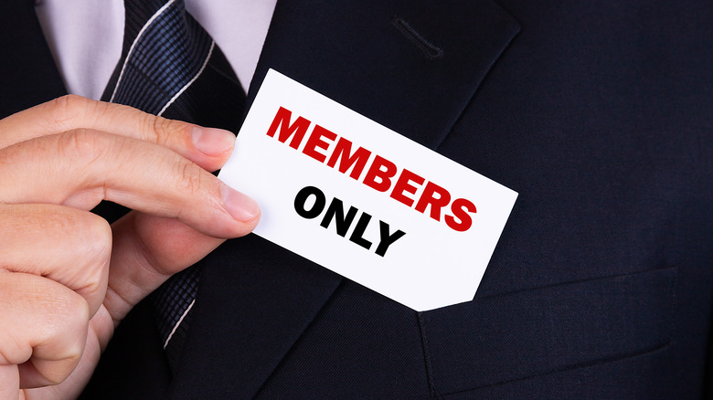 man holding "Members Only" card