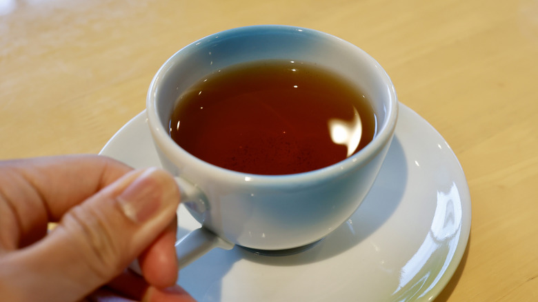 A cup of brown tea in a white mug