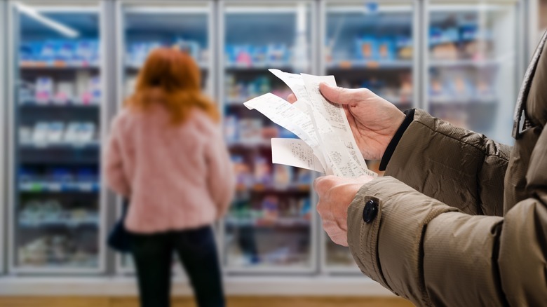 Person reviewing grocery receipt