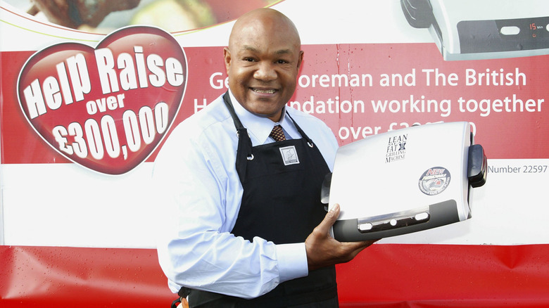 George Foreman smiling holding grill