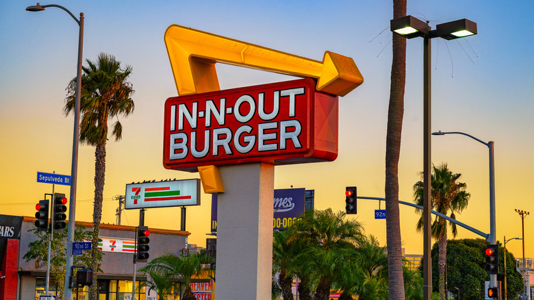 In-N-Out burger sign with palm trees around it