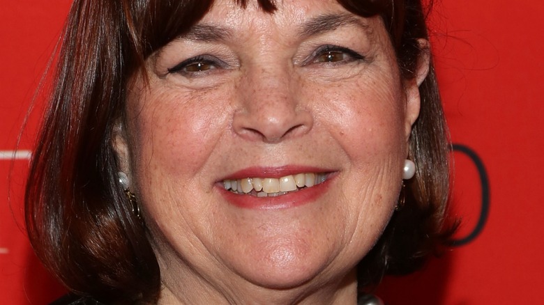 Ina Garten smiles with red lipstick and pearl earrings