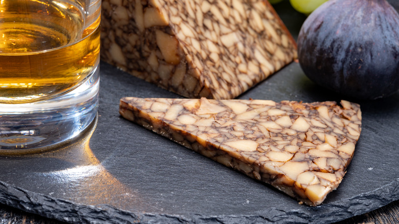Cheese, fig, and whiskey on plate