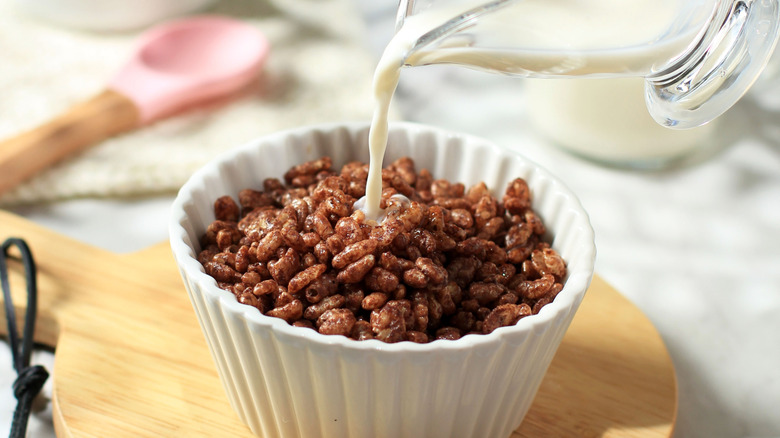 Milk being poured into a bowl of breakfast cereal