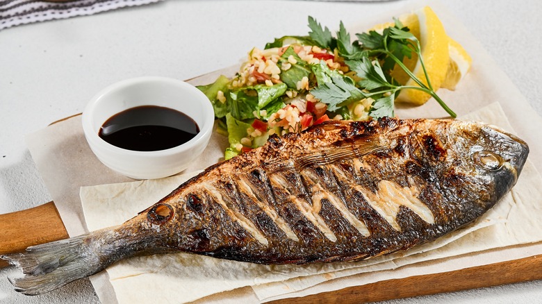 a grilled fish being served