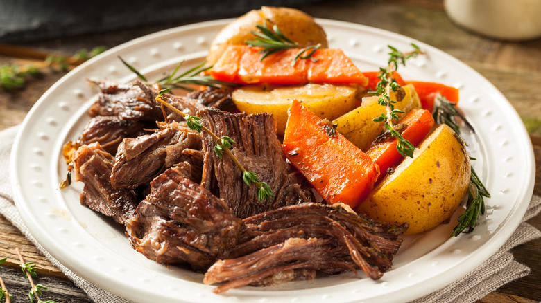 Shredded pot roast plated with carrots and potatoes