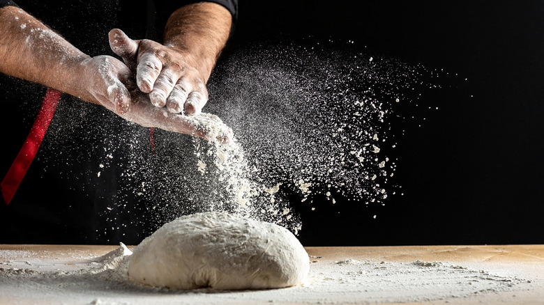 man flouring and kneading bread