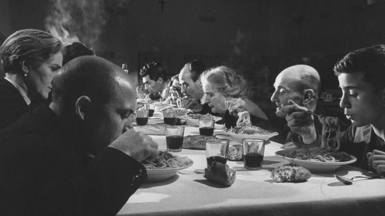 Black and white picture of Italian immigrants eating pasta