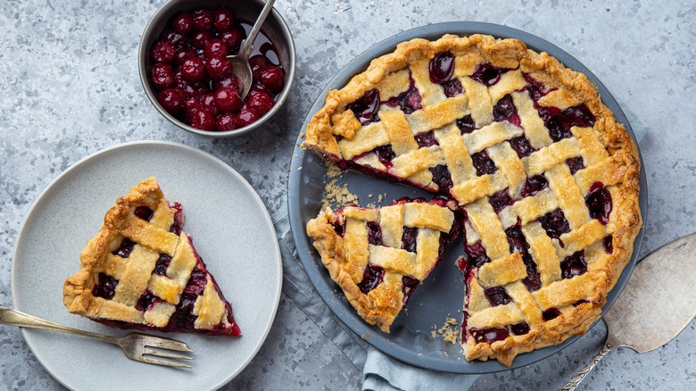 cherry pie sliced with bowl of cherries
