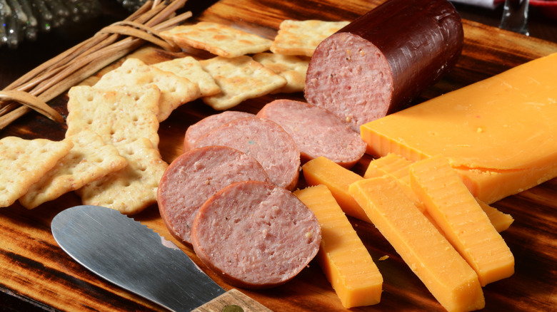 Sliced summer sausage with cheese and crackers