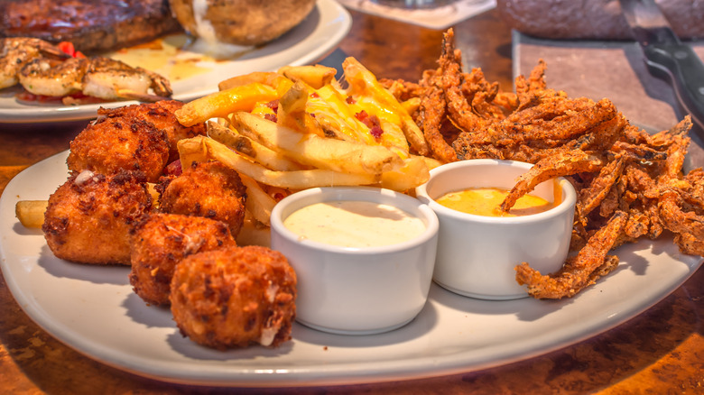 Deep-fried appetizers and dipping sauces on a plate