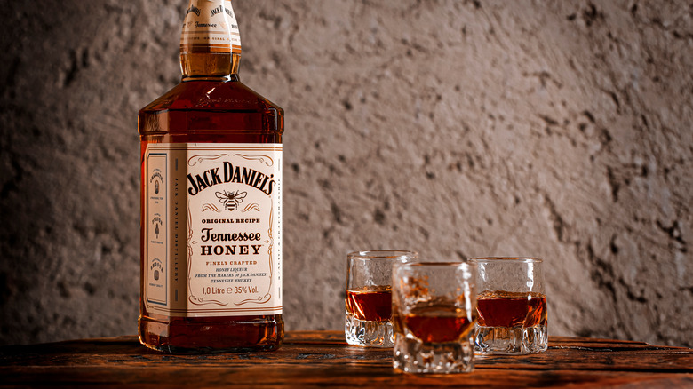 Bottle of Jack Daniel's Tennessee Honey surrounded by shots