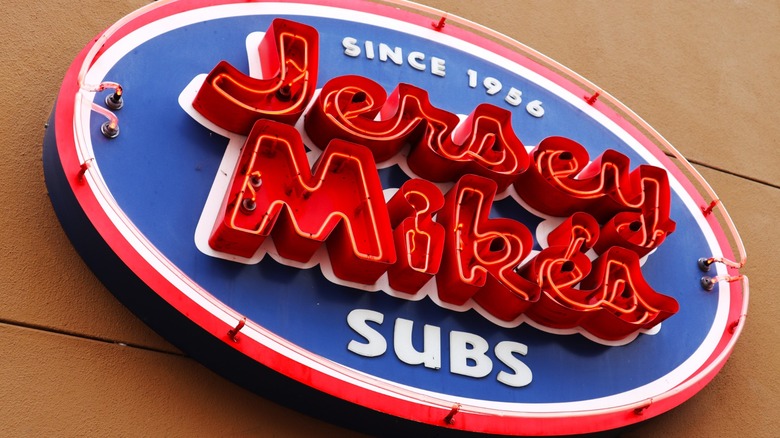 a blue and red and white neon jersey mike's sub sign