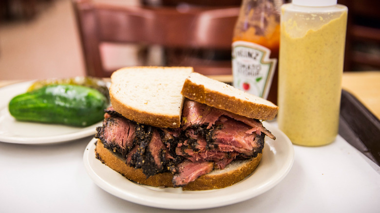 Katz's pastrami sandwich, pickles, condiments on tray