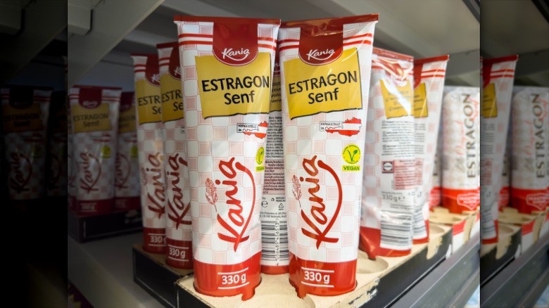 Tubes of a German brand of mustard on a shelf. The label reads Estragon Senf