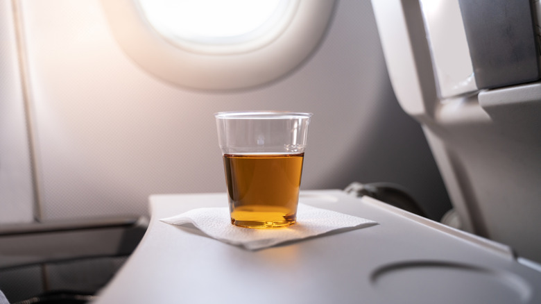 cup with alcohol on airplane tray table