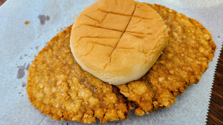 A breaded pork loin sandwich on wax paper