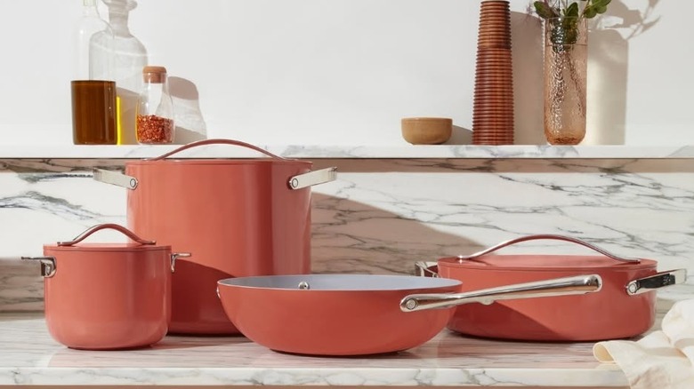 Pink Caraway brand pots and pans on a kitchen counter