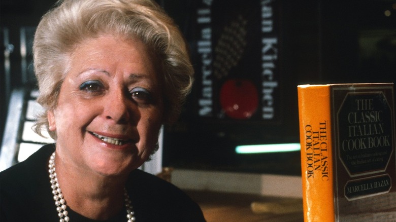Marcella Hazan smiling with cookbook by her side.