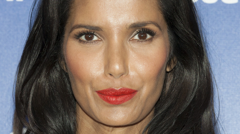 Padma Laksmi smiles with red lipstick